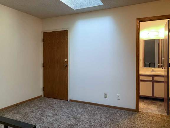 a loft area with a skylight and a door to a bathroom