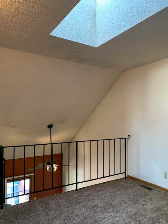 a loft area with a skylight and a metal railing