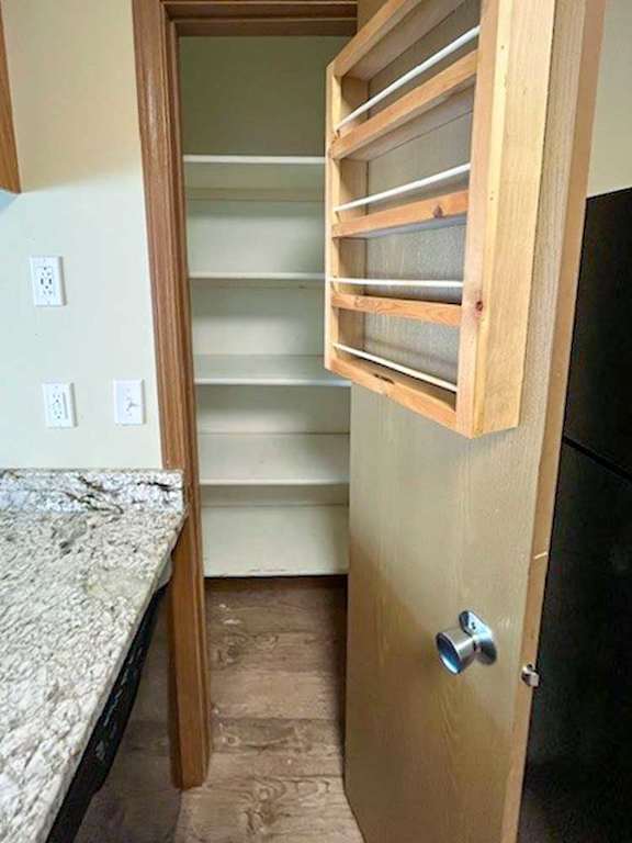 a kitchen with a pantry with additional storage shelves hanging on the door