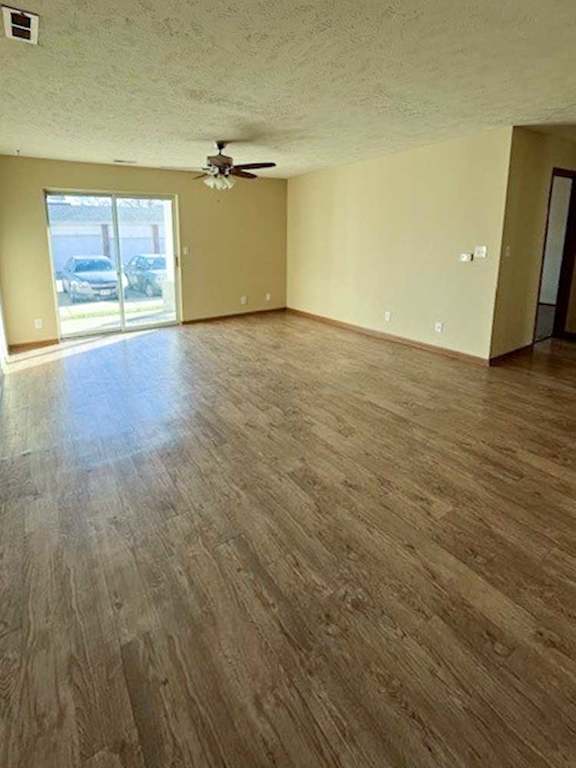 a living room with hardwood flooring and a ceiling fan