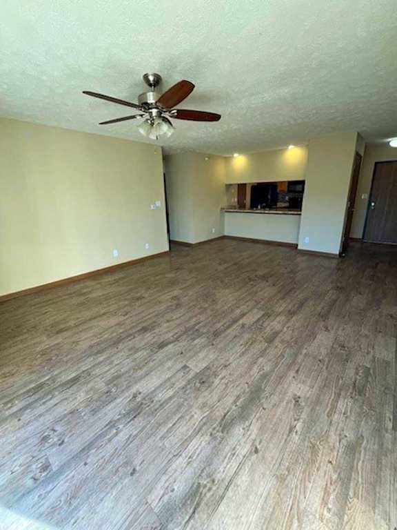 a living room with a ceiling fan and wooden flooring