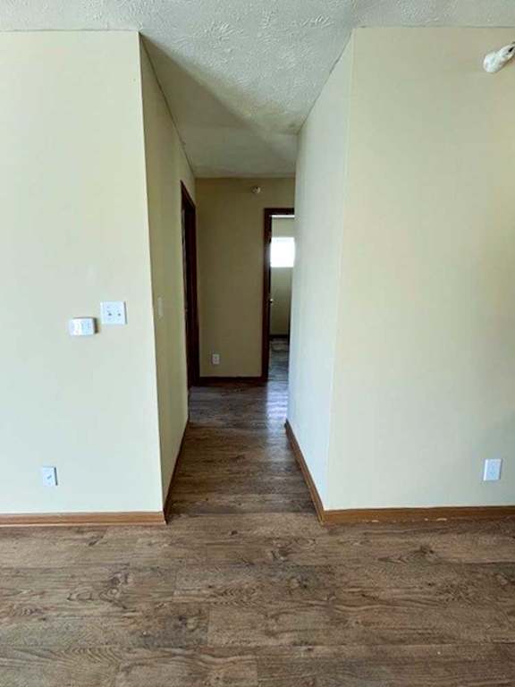 a hallway with wood flooring and white walls