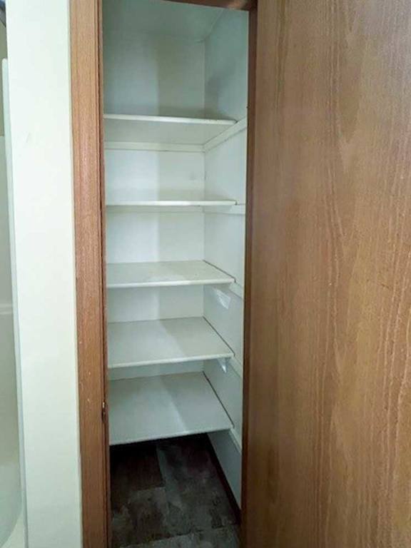 a bathroom linen closet with built-in shelves