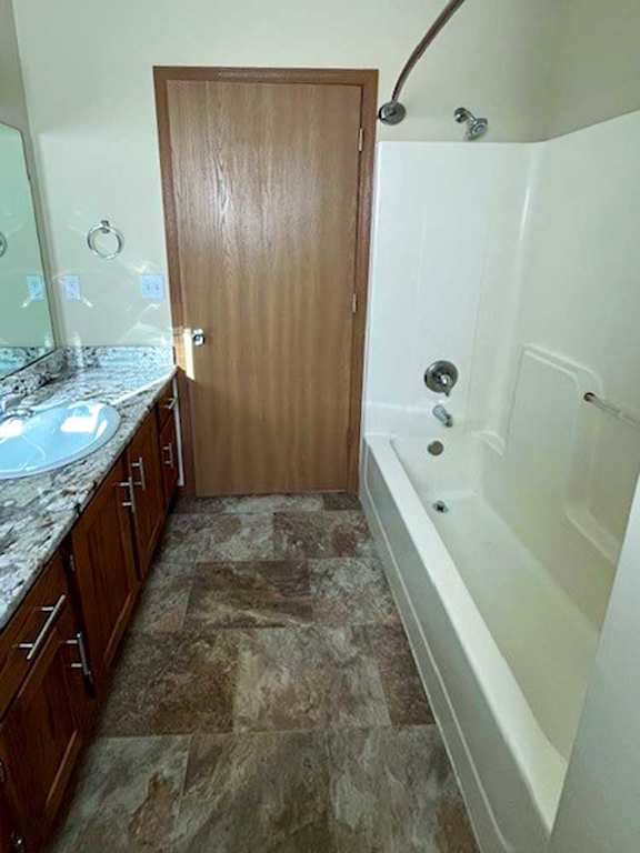 a bathroom with a tub shower, sink, and mirror