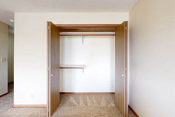 A carpeted loft bedroom with a sliding double-door closet.