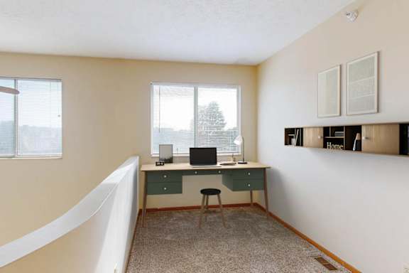 A room with a desk and a chair in it.