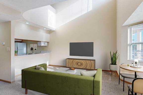 A modern living room with a green sofa and a television.