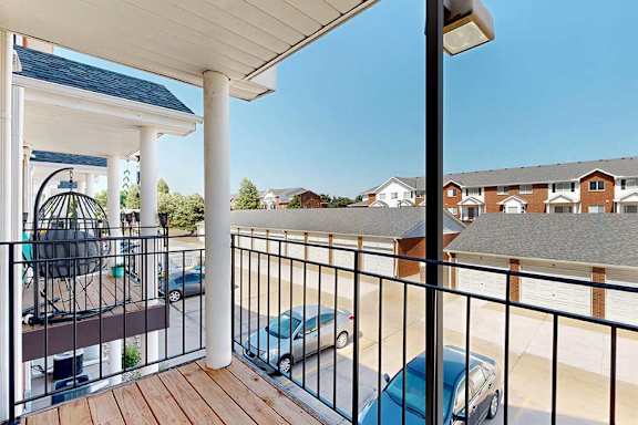 A balcony with a metal railing and a view of neighboring apartments.