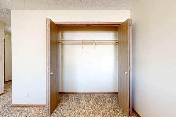 A loft bedroom with an open double-door closet.