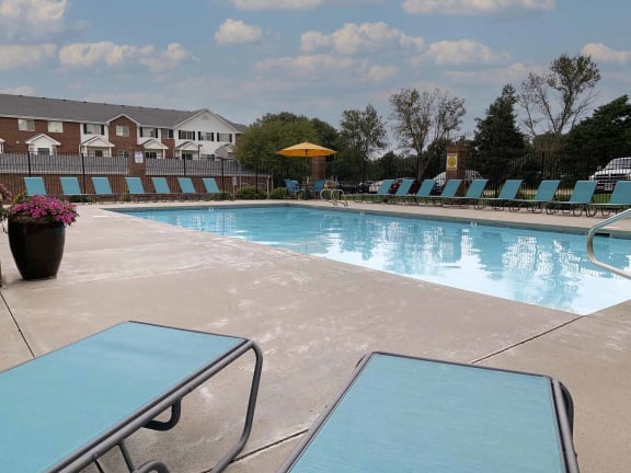 a swimming pool with light blue lounge chairs around it