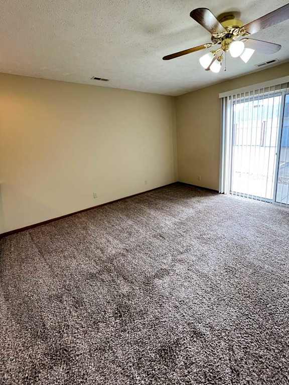a living room and sleeping area with a ceiling fan and carpeted floor