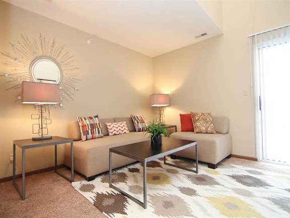 Living room furnished with a couch, side table, rug and lamps