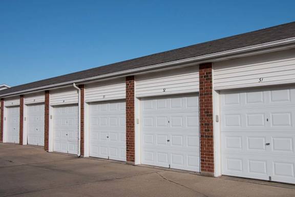 A row of white garage doors are closed