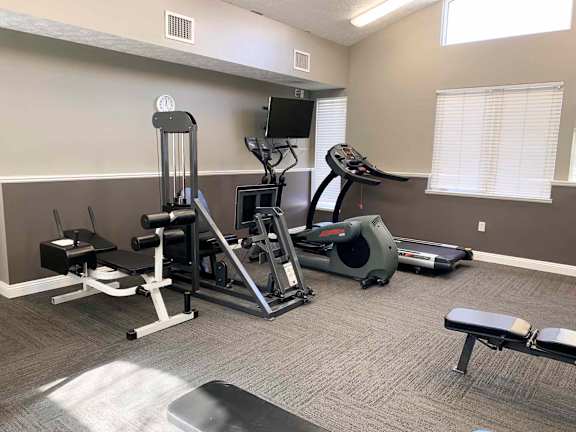 an apartment gym with weights and cardio equipment