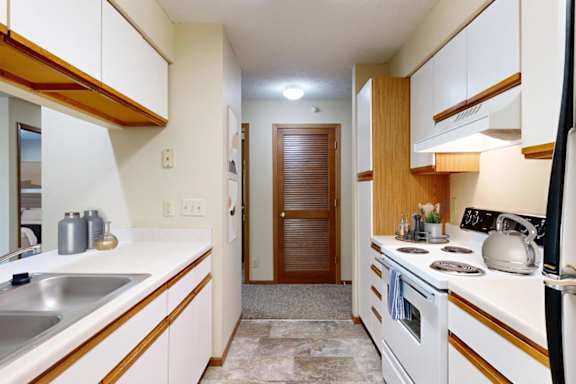 A kitchen with white cabinets and a wooden accent.