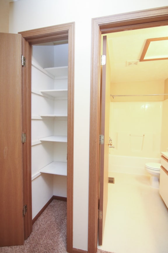 Linen closet with storage shelves next to the bathroom