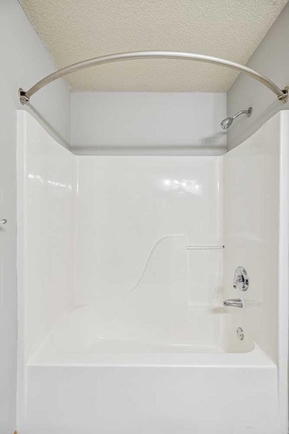 A white bathroom with a tub and shower.