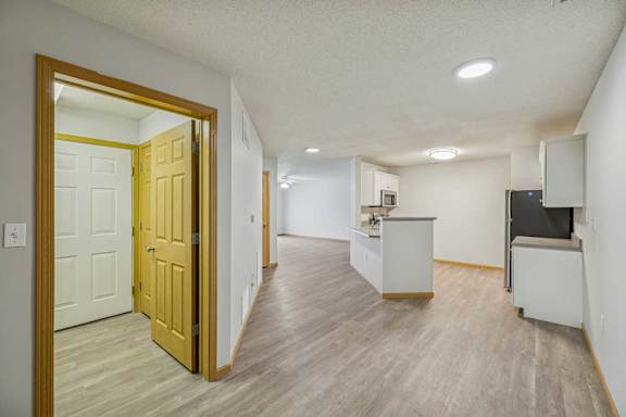A room with a wooden floor and a white wall with a door.