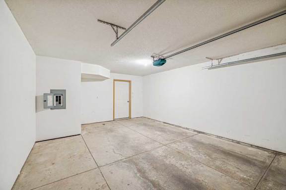 A room with a concrete floor and a door on the right side.