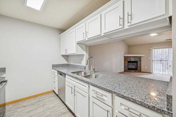 A kitchen with granite countertops and white cabinets.