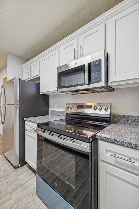 A kitchen with a stove top oven and microwave above it.