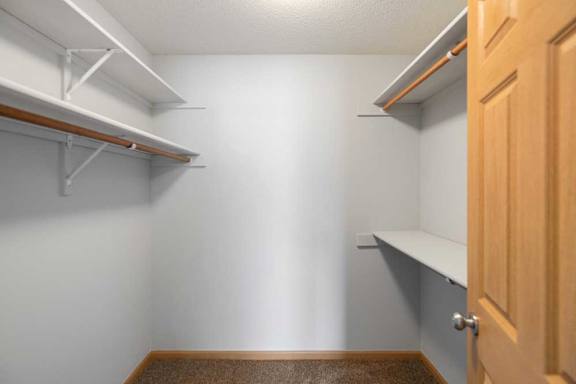 A small, empty room with a wooden floor and a door on the right.