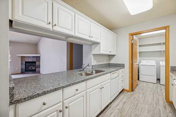 A kitchen with white cabinets and a granite countertop.