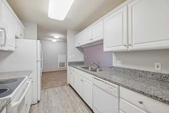 A kitchen with white appliances and cabinets.