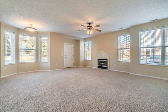 large open living room with tons of windows and a fireplace