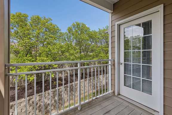 A balcony with a white door and a metal railing.