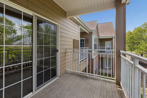 A balcony with a sliding glass door and a railing.