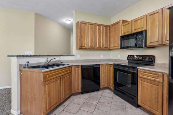 A kitchen with wooden cabinets and black appliances.