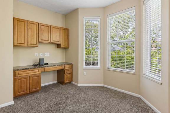 A room with a desk and cabinets.