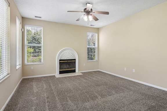 A room with a fireplace and a ceiling fan.