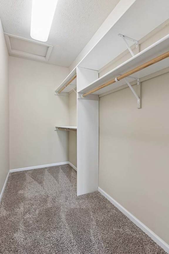 A large walk-in closet with built in shelving.