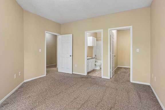 A room with a carpeted floor and a white door.