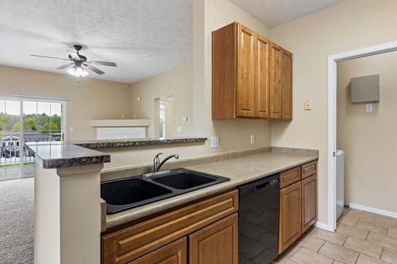 A kitchen with brown cabinets and a black sink.