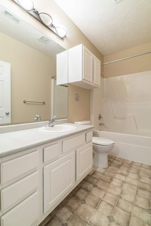 A white bathroom with a toilet, sink, and bathtub.