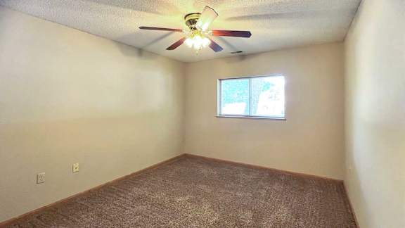 a bedroom with a ceiling fan and a window