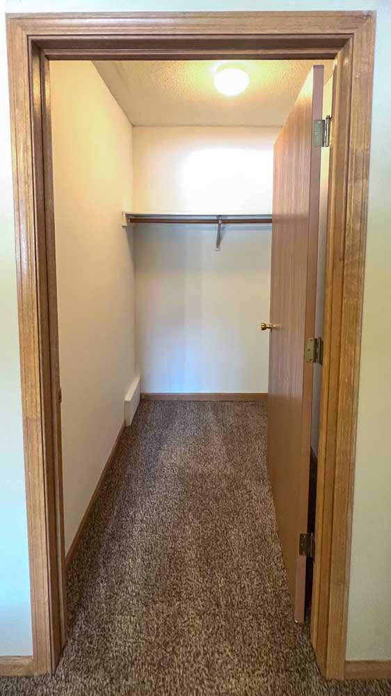 a long walk-in closet with built-in shelving