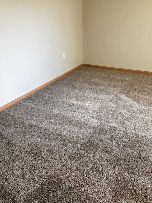a loft bedroom with a grey carpet and a beige wall