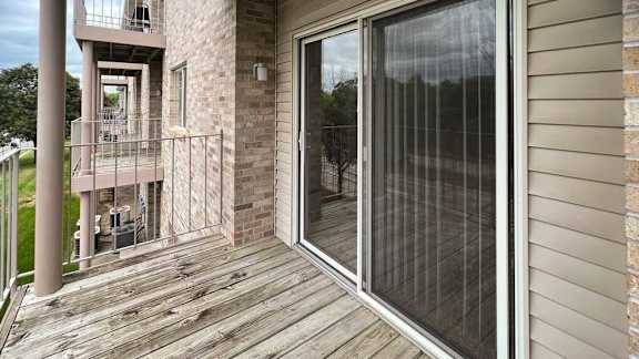 a balcony with a sliding glass door and screen