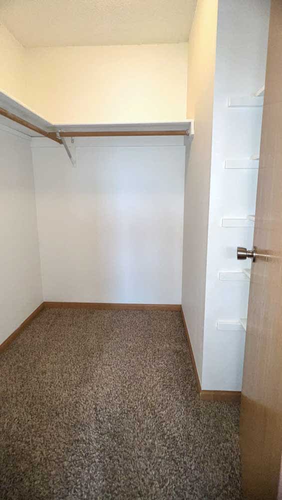 a walk-in closet with built-in hanging space