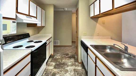 a kitchen with white appliances and white and brown cabinets