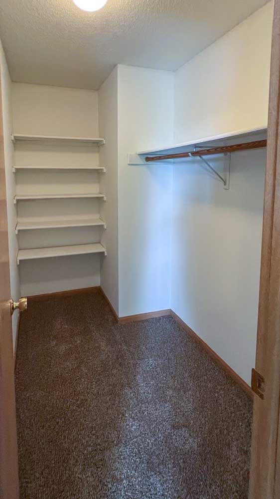 a walk-in closet with built-in shelving and hanging space