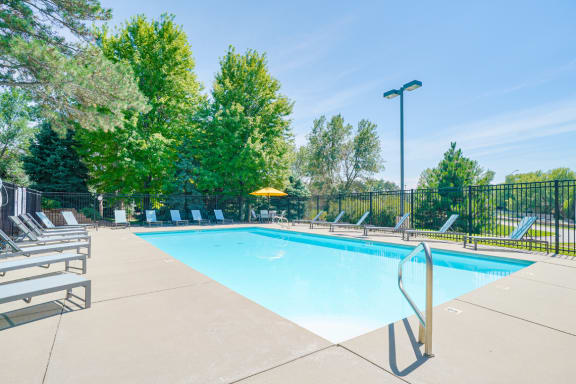 Resort style swimming pool with sun tanning loungers at Skyline View apartments