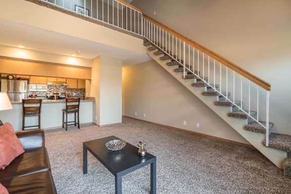 A living room with a staircase leading to the upper floor.