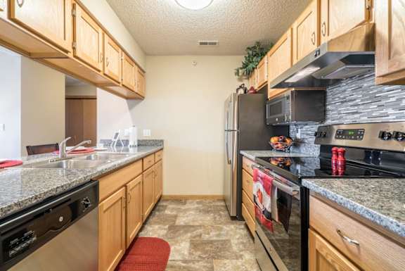 A kitchen with granite countertops and stainless steel appliances.