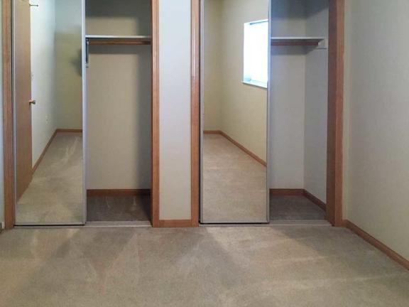 a bedroom with two closets, both with sliding mirror doors