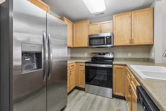 Kitchen with stainless steel appliances, light wood cabinetry, and modern finishes.